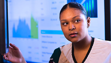 Woman presenting with powerpoint behind