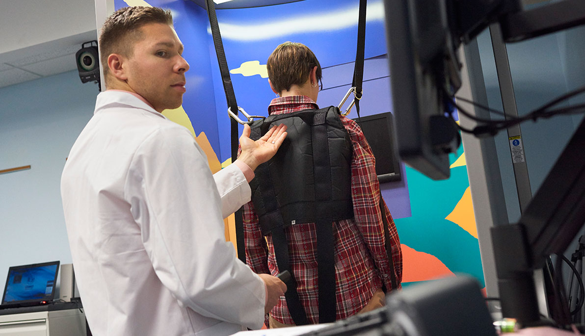 Associate Professor and Director of the Center for Sports Medicine Hallie Zwibel works with a patient on the Balance Master.