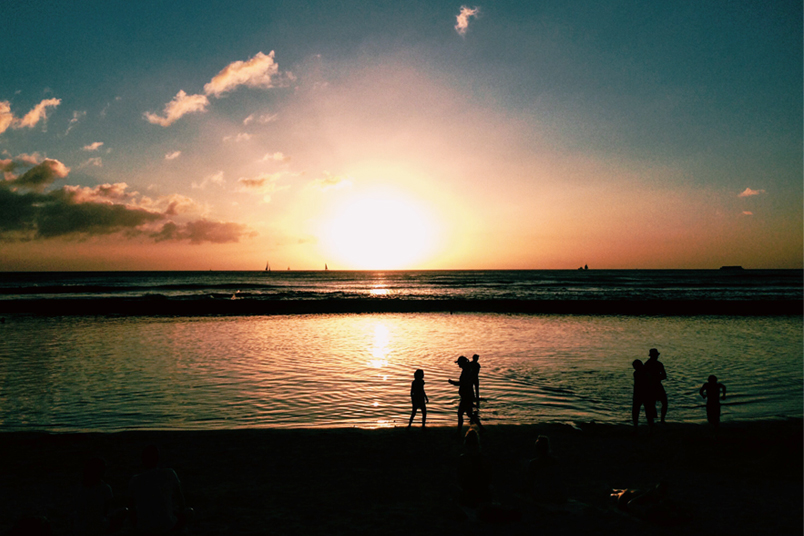 People on the beach during a sunset.