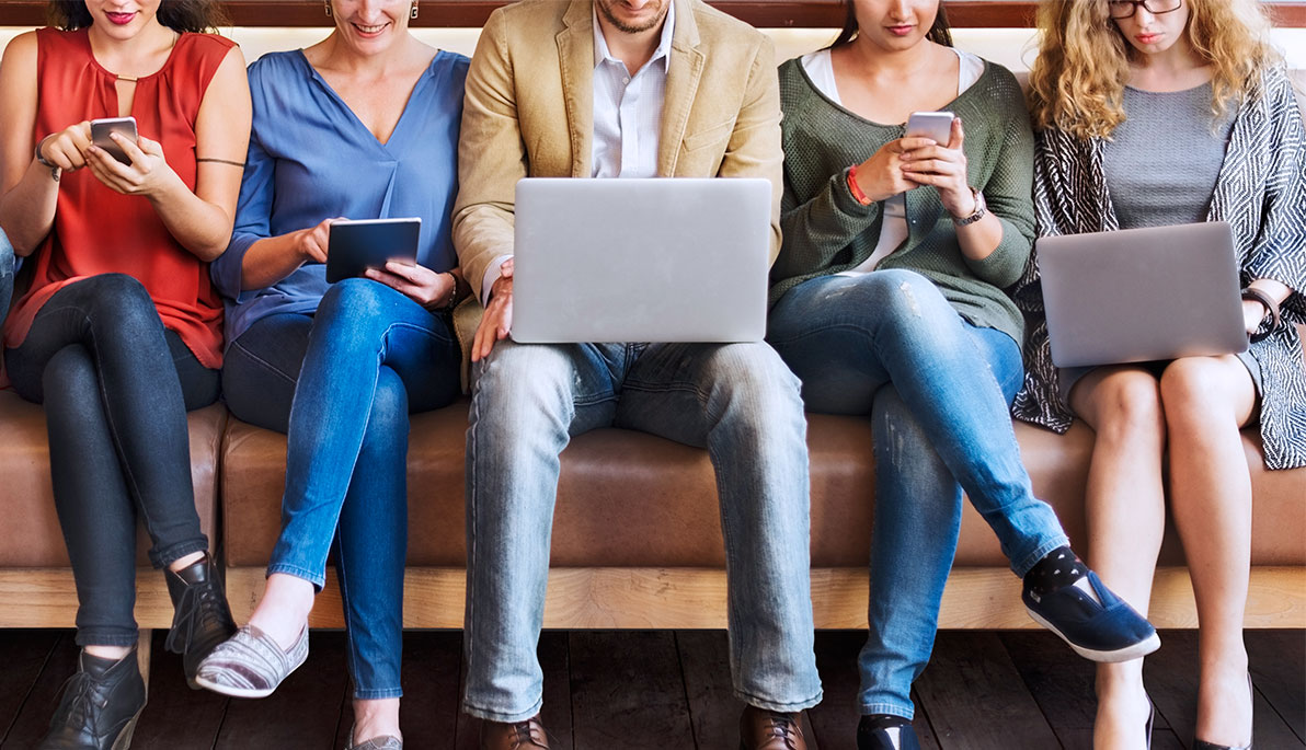 People looking at their laptops and mobile devices. People looking at their laptops and mobile devices.