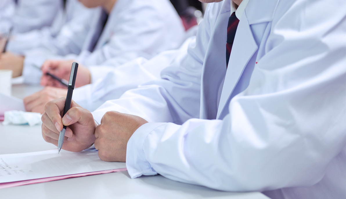 Osteopathic medical student writing at a desk.