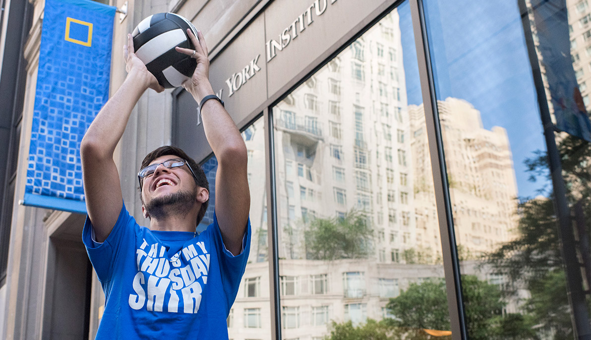 NYIT student holding a volleyball