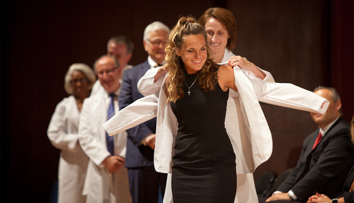 NYITCOM student receiving her white coat.