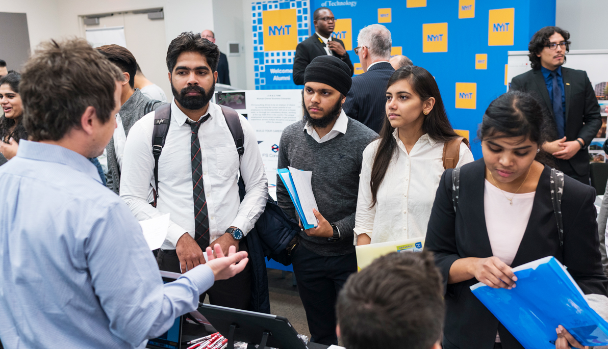 Student listening to a recruiter at the career fair.