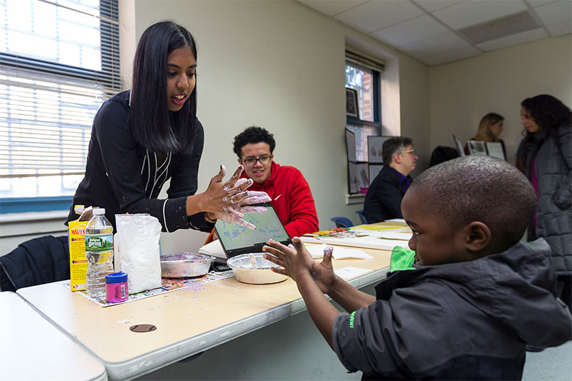 NYIT student shows children how to make their own slime.