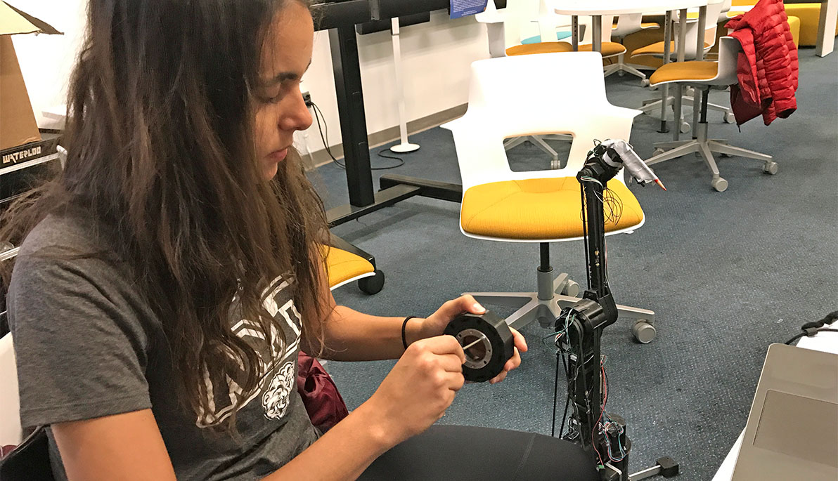 NYIT student building a robot arm.