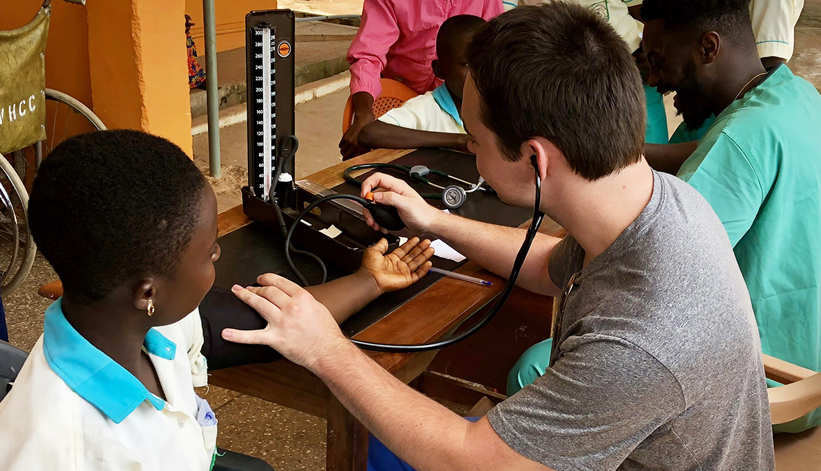 NYIT student taking the blood pressure of a patient.