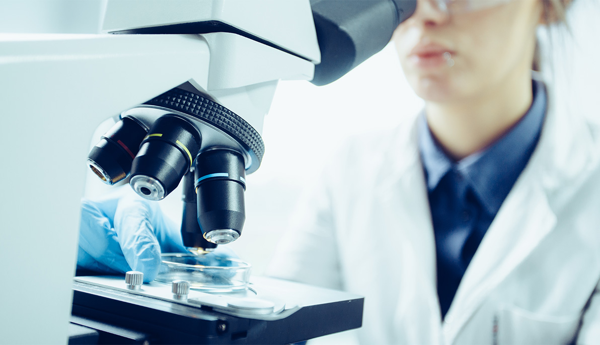 Researcher looking through a microscope