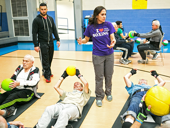 Adena Leder works with participants of Rock Steady Boxing on the Long Island campus