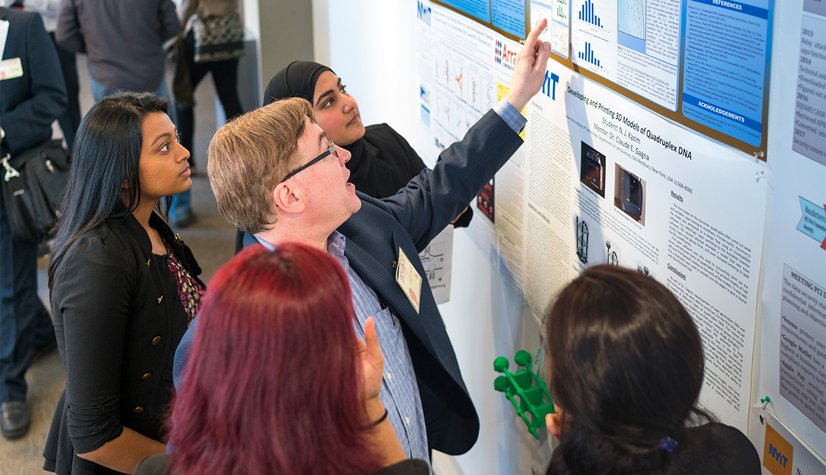 Claude Gagna, Ph.D., discusses scientific research with students at a past SOURCE event.