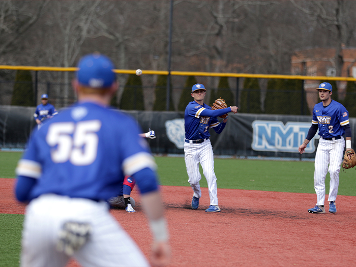 Shortstop Ben McNeill throws baseball towards other player on Bears team