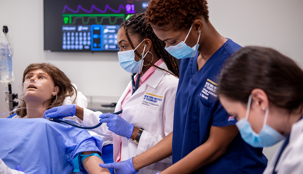 Medical students taking vitals on a dummy