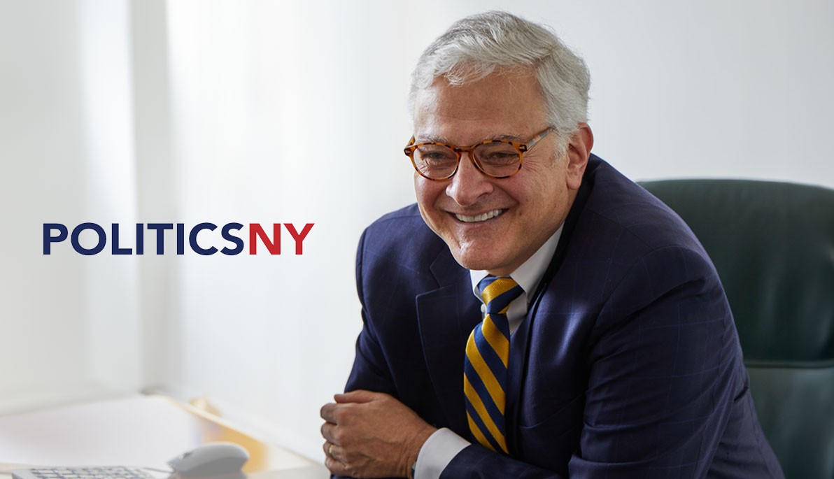 Mashup of PoliticsNY logo and President Hank Foley at his desk