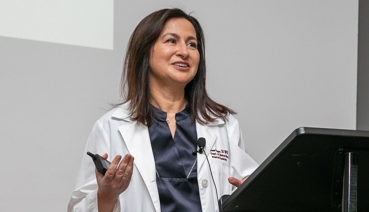 New York Tech Assistant Professor Eleanor Yusupov speaking at a podium