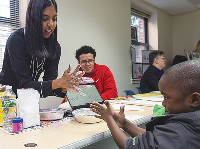 A student shows an open house attendee how to make slime.