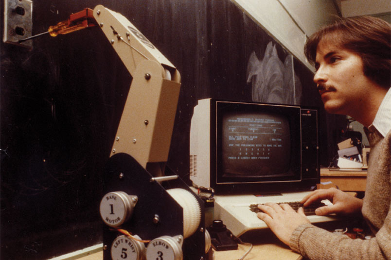 <strong>Throwback Thursday</strong> This photo dates back to 1982 and shows a student examining a robot. NYIT's research in robotics has only grown more vast and rich since then.