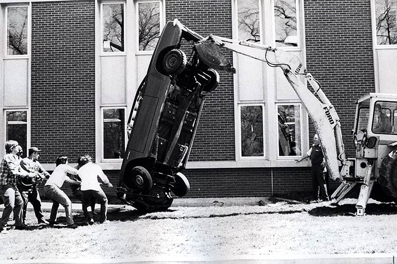 <strong>Throwback Thursday</strong> This photo dates to 1973, when an oil embargo against the United States spurred an energy crisis in the country and renewed the public's interest in electric cars. Engineering students under the direction of Professor Edward Kafrissen, Ph.D., lowered a 1965 General Motors Corvair into the machine shop inside Harry Schure Hall at the Old Westbury campus. The group later removed the engine and installed an electric motor with a rechargeable battery.