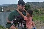 Student Robby O’Malley takes a break to have some fun with two local children.