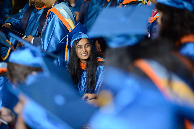 A new NYIT alumna chats with her fellow classmates.