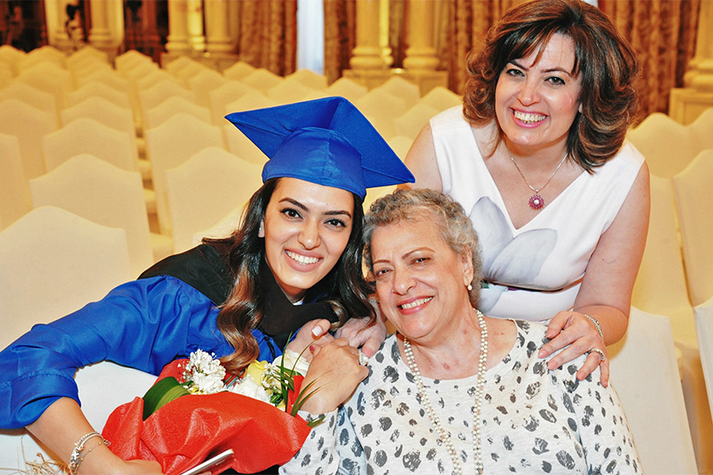 A new alumna poses for a photo with her family.