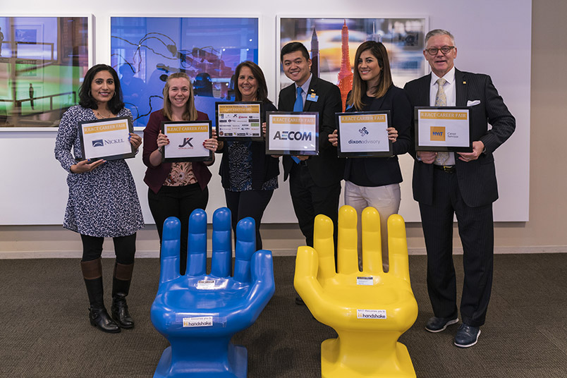 (left to right) Career Services staff members Saadia Rafiq, Angela Monahan, Laurie Hollister, James Huang, Sudeh Jahan, and John Hyde hold up signs representing employers at the fair.